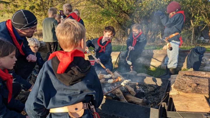 Spejdere der laver snobrød ved et bål