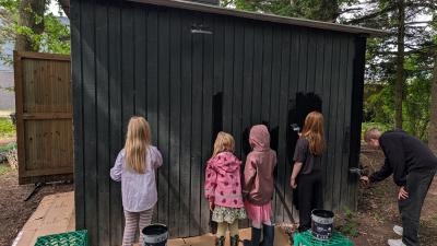 Fra arbejdsdagen: børn og voksne maler skuret